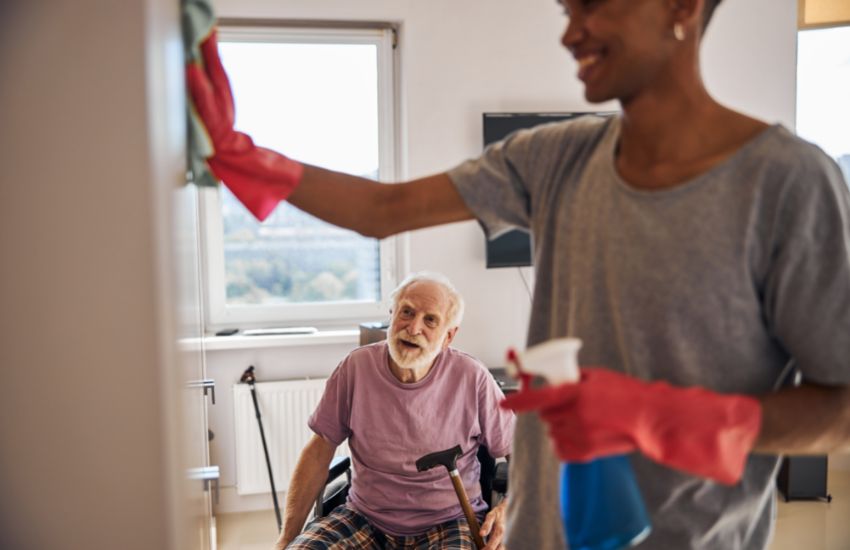 cleaner helping old disable man