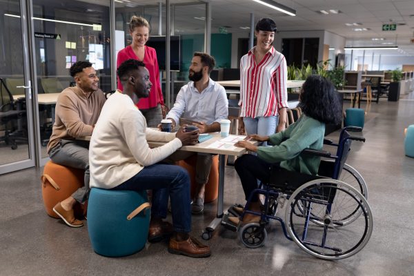 Disabled african american female advisor discussing with biracial colleagues in meeting at workplace. unaltered, disability, business, teamwork and modern office concept.